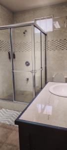 a bathroom with a shower and a sink at Spice N Honey in Port-of-Spain