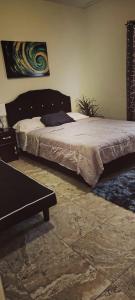 a bedroom with a bed and a bench in it at Spice N Honey in Port-of-Spain