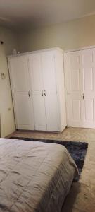 a bedroom with two white cabinets and a bed at Spice N Honey in Port-of-Spain