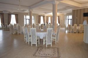 a banquet hall with white tables and chairs at New Continent in Bushtyno