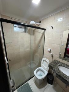 a bathroom with a shower and a toilet and a sink at Apartamento Central in Montes Claros +14 photos