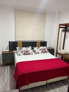 a bedroom with a bed with a red blanket at Apartamento Central in Montes Claros