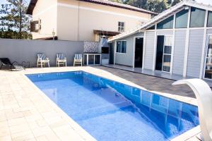 a swimming pool in front of a house at pousada campolim prox ao hospital Bos in Sorocaba
