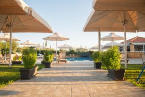a patio with umbrellas and a swimming pool at Stomio Villague in Filiatra