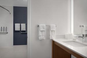a bathroom with a sink and a shower with towels at Residence Inn by Marriott Provo North University in Provo