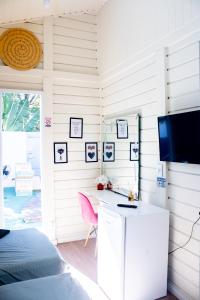 a bedroom with a desk and a tv on a wall at pousada campolim prox ao hospital Bos in Sorocaba