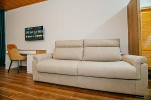 a couch sitting in a living room with a table at Villa Mirakula Kvariati in Kvariati