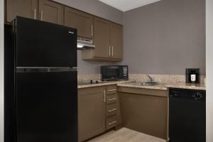 a kitchen with a black refrigerator and a sink at Residence Inn by Marriott Provo North University in Provo
