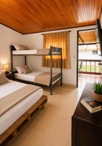 a bedroom with two bunk beds and a balcony at Complejo Campestre Salome Cabañas & Hotel in Calima