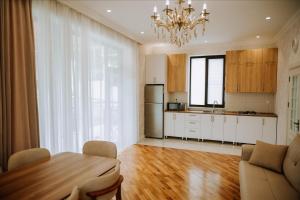 a kitchen and dining room with a table and a chandelier at Quba Garden Resort in Quba