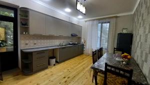 a kitchen with a dining table and a kitchen with white cabinets at Village in Oğuz