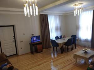 a living room with a table and chairs and a television at Village in Oğuz