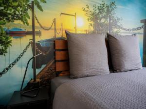 a bed with two pillows next to a body of water at Le temps de la pause 1 in Cepoy +14 photos