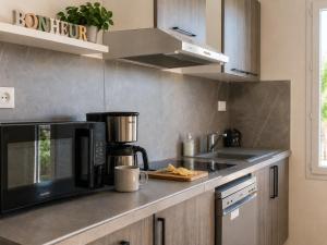 a kitchen with a microwave and a coffee maker on a counter at Le temps de la pause 1 in Cepoy