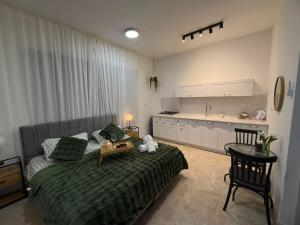 a bedroom with a large bed and a kitchen at קסם צפתי in Safed