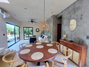a dining room and living room with a table and chairs at Design Luxury Villa in Holbox Island