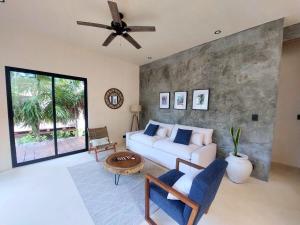 a living room with a white couch and a ceiling fan at Design Luxury Villa in Holbox Island