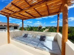 a bed on a balcony with a wooden pergola at Design Luxury Villa in Holbox Island