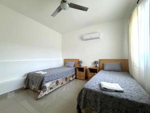 a bedroom with two beds and a ceiling fan at Crystal Bay View Apartment in Kalogrea +27 photos
