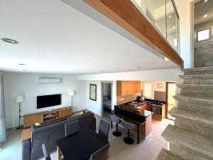 a living room with a staircase and a television at Crystal Bay View Apartment in Kalogrea