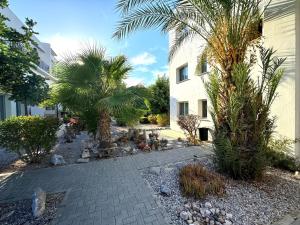 a courtyard with palm trees and a building at Crystal Bay View Apartment in Kalogrea