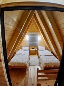 a room with three beds in a attic at Djedina Gora Cabins in Poda