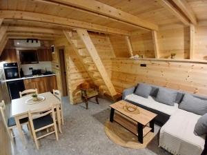 a living room with a couch and a table at Djedina Gora Cabins in Poda