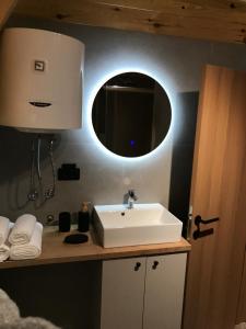 a bathroom with a white sink and a mirror at Djedina Gora Cabins in Poda