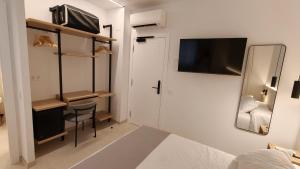 a small room with a bed and a chair and a tv at Hostal Manel in Pineda de Mar