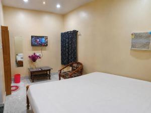 a bedroom with a bed and a tv on the wall at Ratnadeep Palace - Near Kashi Vishwanath Temple & Ghats in Varanasi