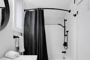 a bathroom with a shower with a black shower curtain at Modern 1 Bdrm with Laundry, BBQ, Deck in Welland
