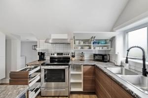 a kitchen with stainless steel appliances and a sink at Modern 1 Bdrm with Laundry, BBQ, Deck in Welland +8 photos