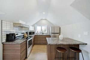 a kitchen with a counter and two stools at Modern 1 Bdrm with Laundry, BBQ, Deck in Welland
