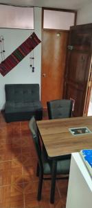 a dining room with a table and a couch at Hospedaje Apu San Isidro in Urubamba