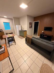a large living room with a couch and a kitchen at Apto centro 03 in Tubarão
