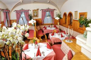 un restaurante con mesas, sillas rojas y flores en Schreiner's - Das Waldviertel Haus, en Laimbach am Ostrong