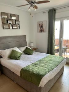 a bedroom with a large bed with green pillows at Casa Emperador Penthouse in Roldán +35 photos
