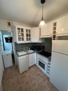 a kitchen with white cabinets and a sink at Spacious 3-room apartment in Fréjus