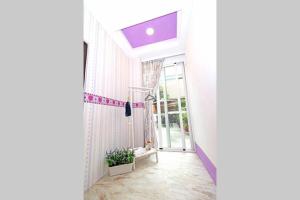 a hallway with a window and a purple ceiling at Qing Noise Villas in Hualien City