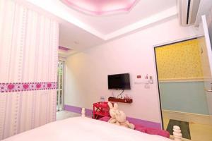 a bedroom with a bed with a stuffed animal on it at Qing Noise Villas in Hualien City