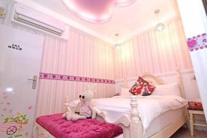 a pink bedroom with a teddy bear sitting on a bed at Qing Noise Villas in Hualien City
