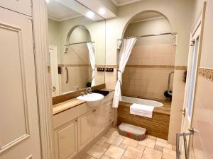 a bathroom with a sink and a tub and a toilet at Porters Cottage Garden in Albury +17 photos