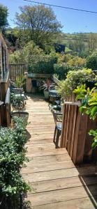 a wooden walkway with benches and tables and plants at Brunant Arms Hotel in Caio