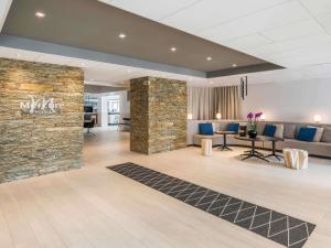 a lobby of a hotel with a stone wall at Mercure Hotel & Spa Bastia Biguglia in Biguglia