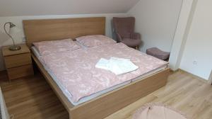 a bedroom with a bed with a pink comforter at Rekreačné domy pod Vlkolíncom in Ružomberok