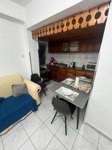 a room with a bed and a table and a kitchen at Apartament 33 in Elbasan
