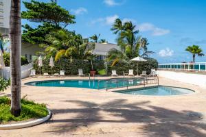 a pool with chairs and umbrellas in a resort at Premier Ocean Lagoon Studio · Condado with Pool in San Juan