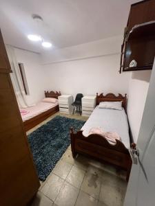 a bedroom with two beds and a couch at Apartament 33 in Elbasan