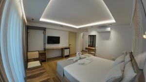 a hotel room with a bed and a flat screen tv at Vila Kosteli in Himare