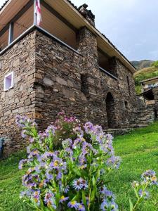 a stone building with a bunch of flowers in front of it at Gudani Temi in Gudani